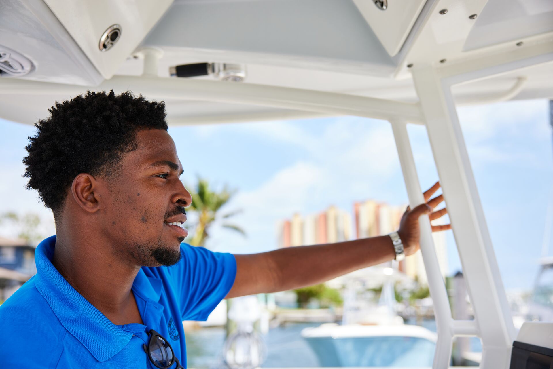 A man smiling and driving a boat, gifts for boat owners on Father's Day. 