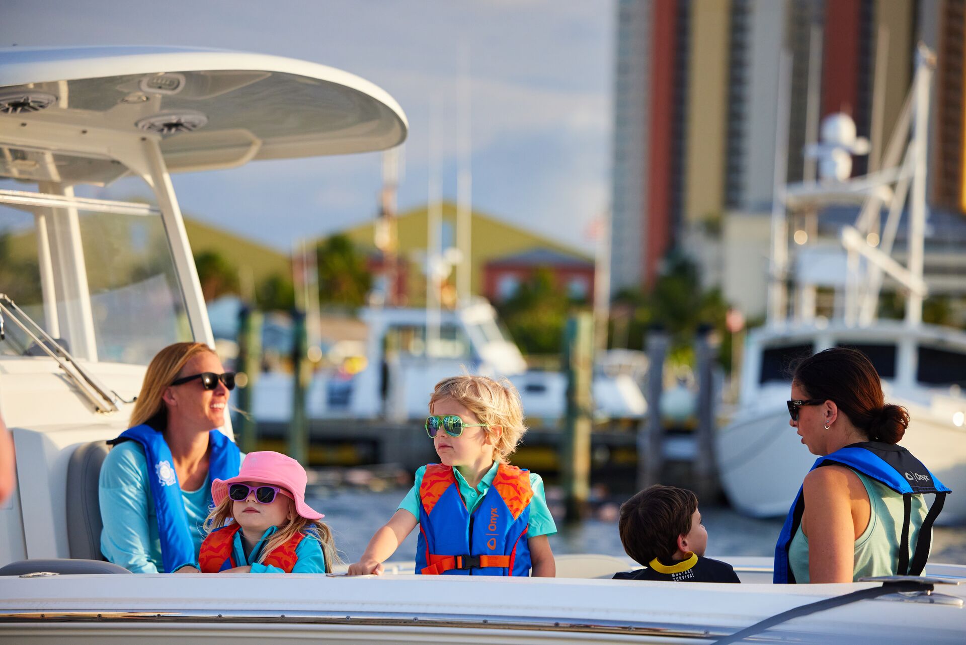 Women and children in lifejackets on a boat, safety equipment for yachts concept. 