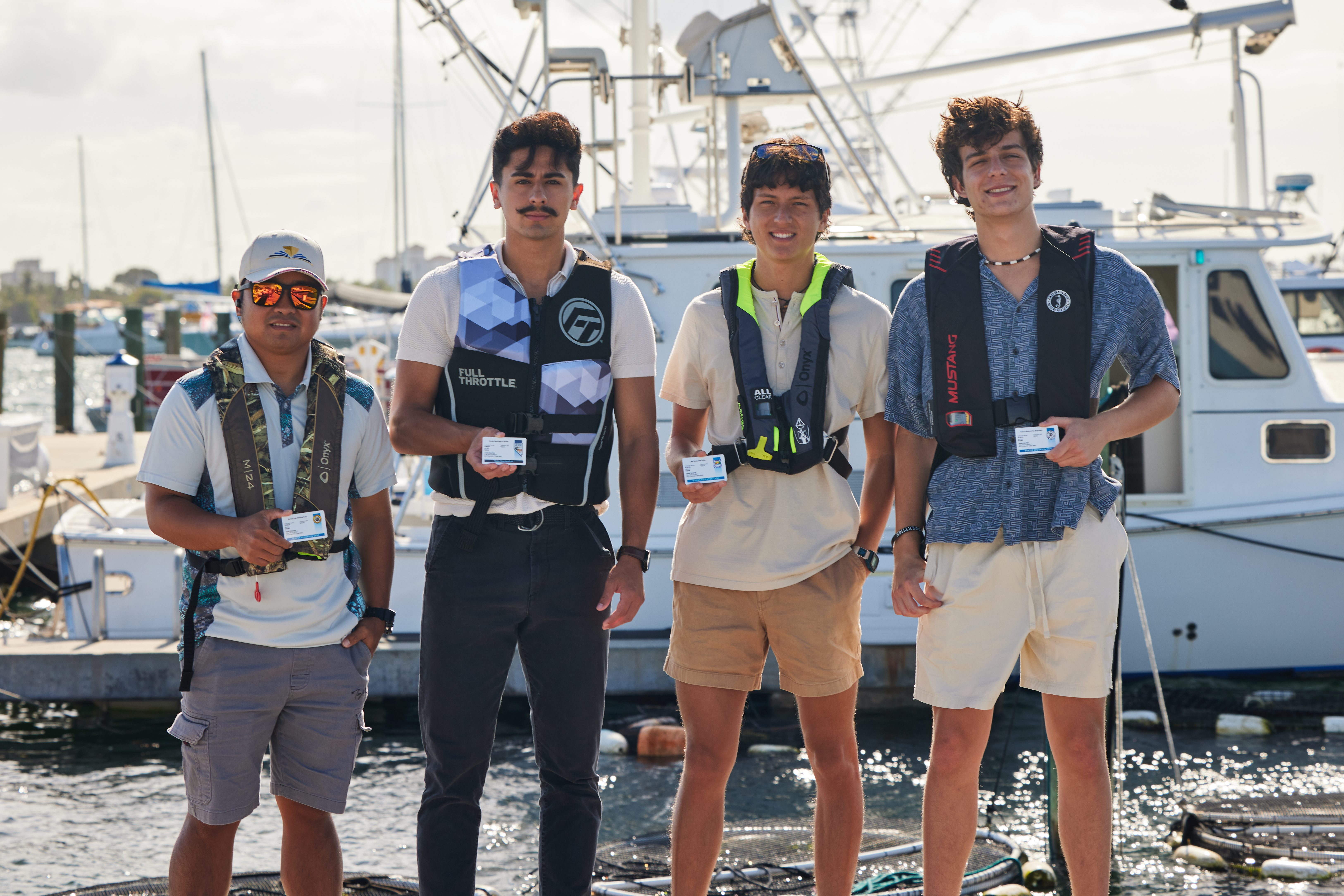 Four guys with boater safety cards, avoiding falling overboard concept. 